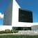 A modern building with tinted windows and a cement pathway